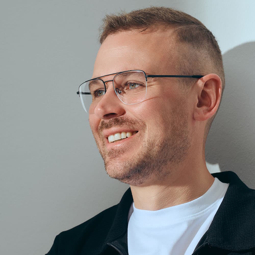 Mann mit schwarzer korrektionsbrille und beigen pullover